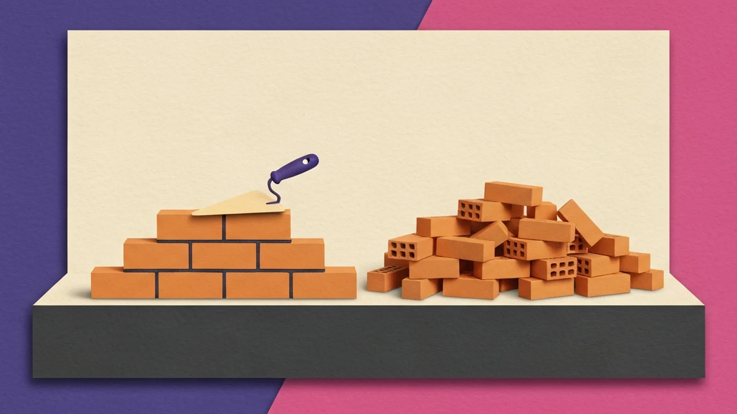 A brick wall three courses high with a trowel resting on top of it, open space above, and a far larger pile of loose bricks stacked beside it waiting to be laid